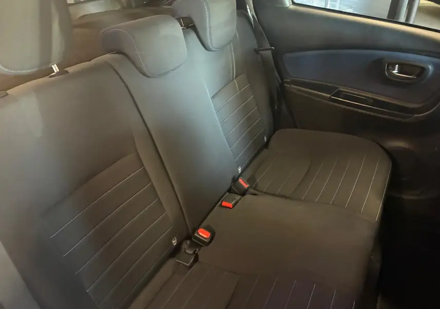 Vue intérieure du siège arrière côté droit de la Toyota Yaris hybride 2020 avec sellerie tissu noire et ceintures rouges.