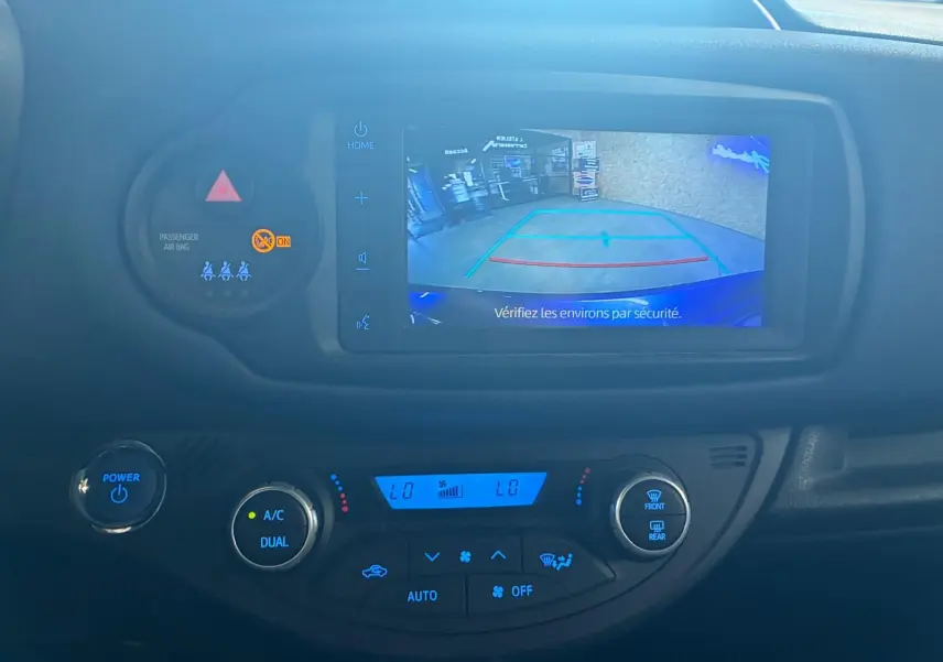 Vue rapprochée de l’écran de caméra de recul et de la console de climatisation d’une Toyota Yaris hybride 2020.