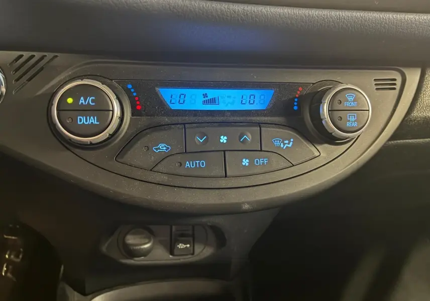 Panneau de commande de climatisation digitale bleu dans une Toyota Yaris hybride 2020, vue frontale rapprochée.