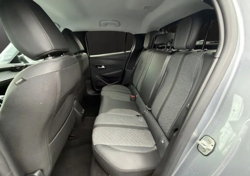 Vue intérieure côté droit sur la banquette arrière en tissu et cuir de la Peugeot 208 gris clair 2025.