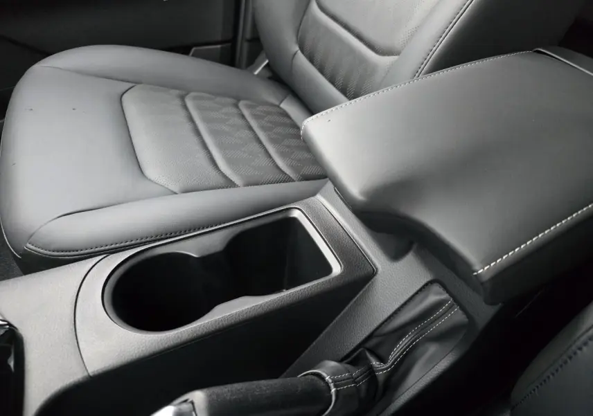 Gros plan sur la console centrale noire et le siège conducteur en cuir gris du pick-up Isuzu D-MAX III NEW 2025.