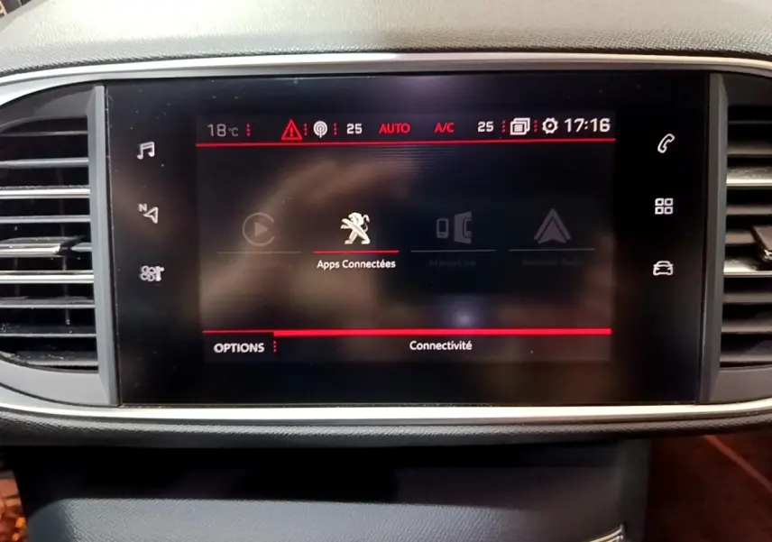 Écran tactile central affichant les applications connectées dans le tableau de bord d'une Peugeot 308 blanche.