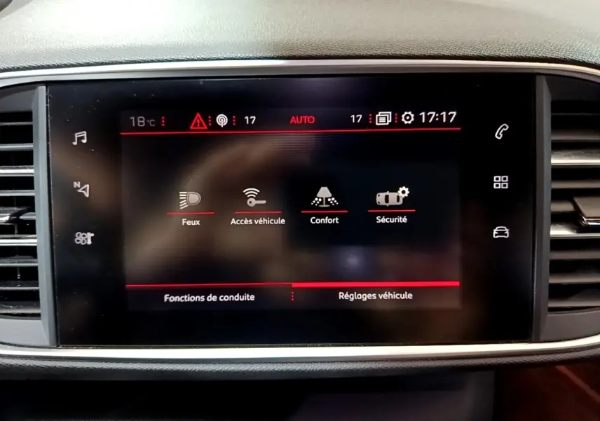 Écran tactile central du tableau de bord de la Peugeot 308 blanc, affichant les réglages de conduite et sécurité.