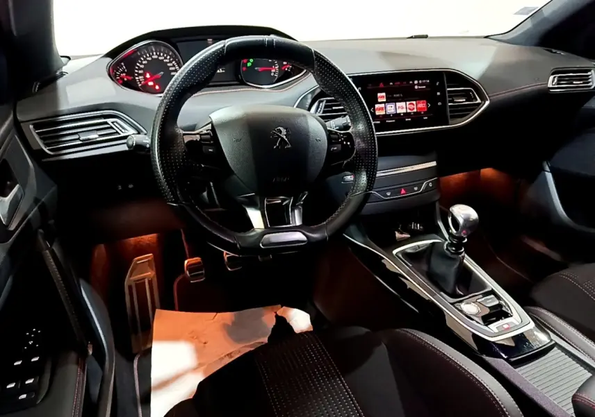 Intérieur de la Peugeot 308 GT Line 2019, vue avant centrée sur le volant cuir et la console avec boîte manuelle.
