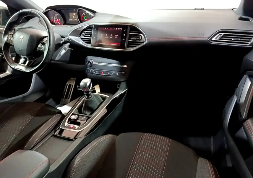Intérieur noir de la Peugeot 308 GT Line 2019, vue de face montrant tableau de bord, volant cuir et écran tactile central.