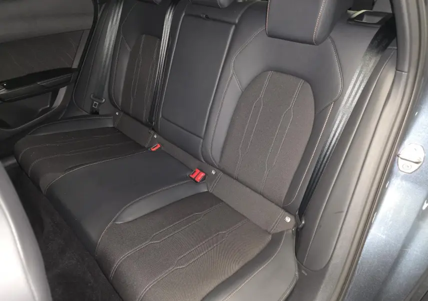 Vue intérieure de la banquette arrière bimatière noire du CUPRA Formentor gris, avec ceinture de sécurité et porte ouverte.