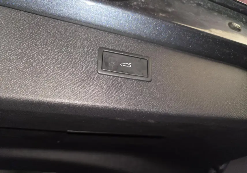 Bouton d'ouverture du hayon sur la partie intérieure du coffre du CUPRA Formentor gris 2025.