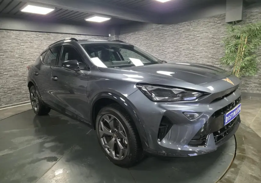 Vue 3/4 avant droit d'un CUPRA Formentor gris métallisé avec jantes alliage 18'' et signature lumineuse Tri-LED.