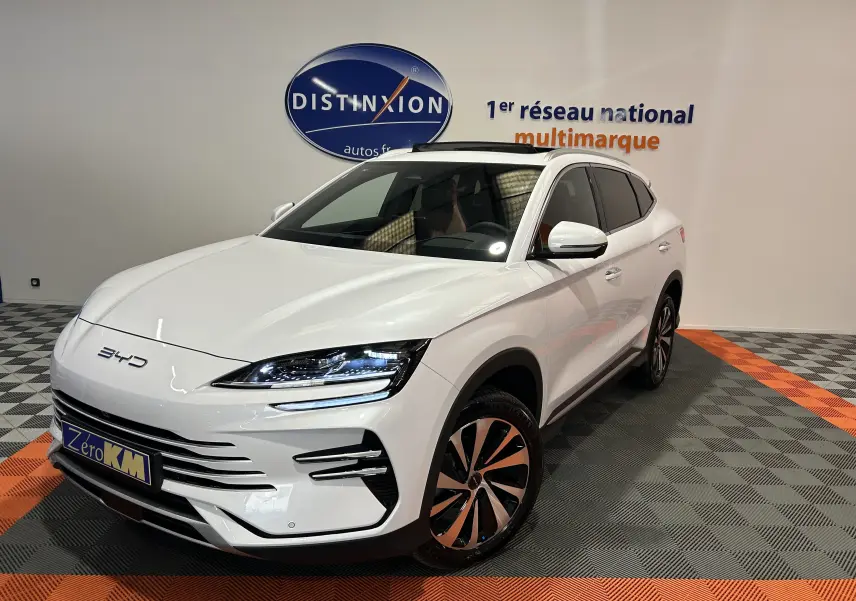 Vue 3/4 avant droite d'un BYD SEAL U blanc neige avec toit ouvrant et jantes bicolores en concession.