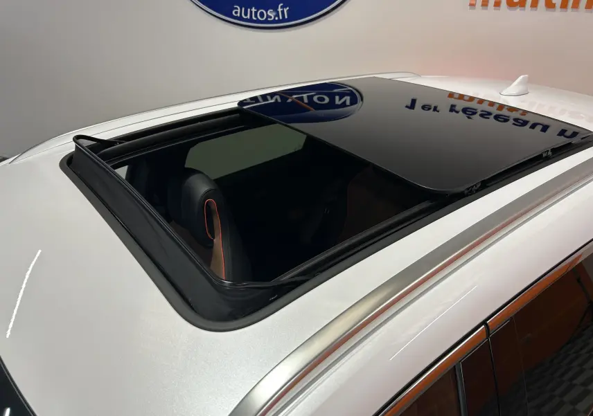 Toit ouvrant panoramique ouvert vu en plongée sur un BYD SEAL U blanc nacré avec intérieur cuir marron.
