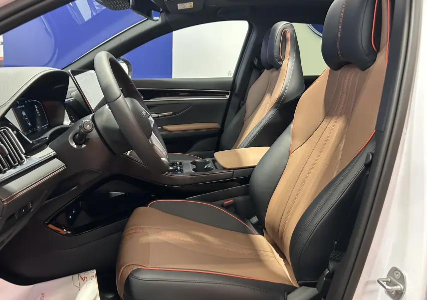 Vue intérieure côté gauche du poste de conduite du BYD SEAL U 2025 avec sièges cuir marron et noir et toit ouvrant.