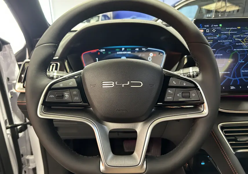 Vue rapprochée du volant noir du BYD SEAL U 2025 avec tableau de bord numérique et écran tactile latéral.
