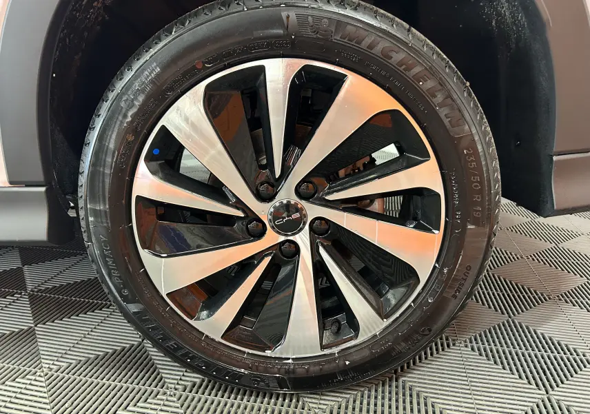 Gros plan sur la jante alliage bicolore noir et argent du BYD SEAL U Snow White Metal, avec pneu Michelin visible.