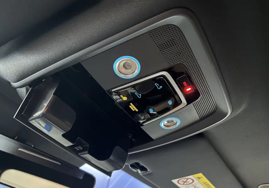 Vue intérieure en plongée du plafonnier noir avec commandes tactiles éclairées et compartiment ouvert du BYD SEAL U blanc.