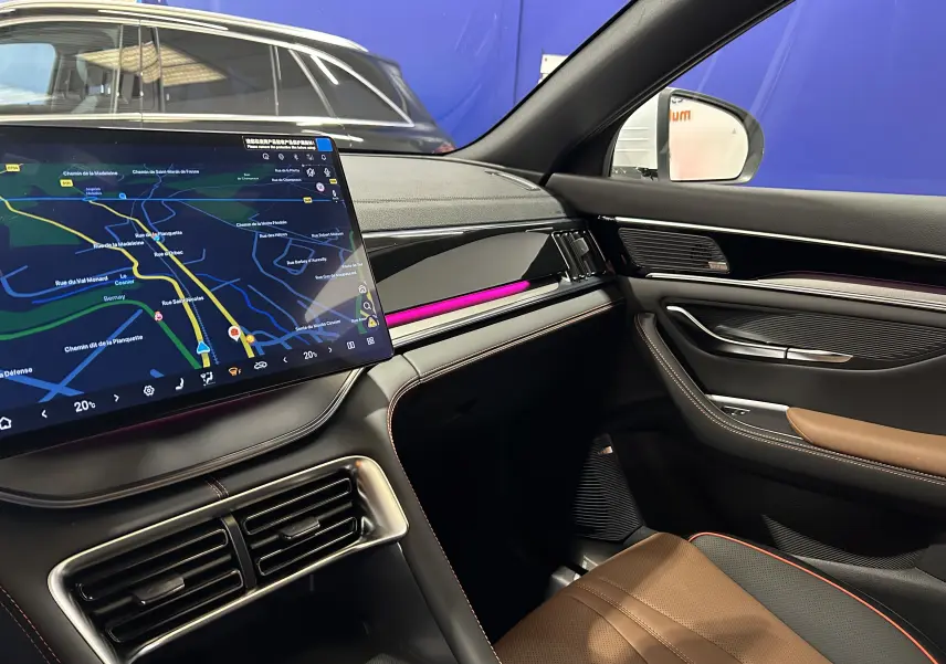 Vue intérieure côté passager du BYD SEAL U 2025 avec écran tactile, éclairage d'ambiance violet et sellerie cuir marron.