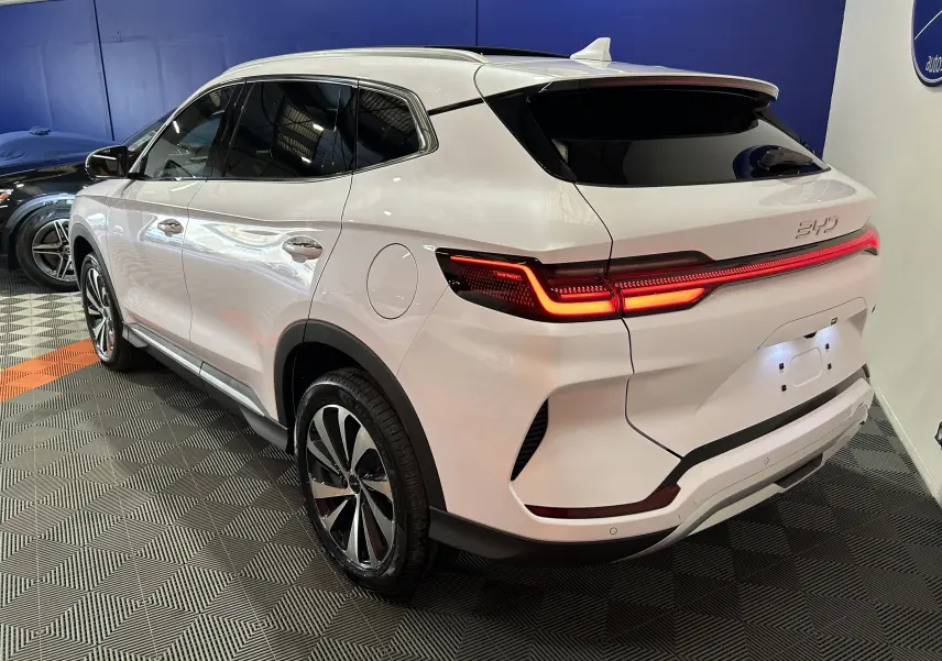 Vue 3/4 arrière droite du SUV BYD SEAL U blanc nacré avec feux arrière LED allumés dans un showroom.