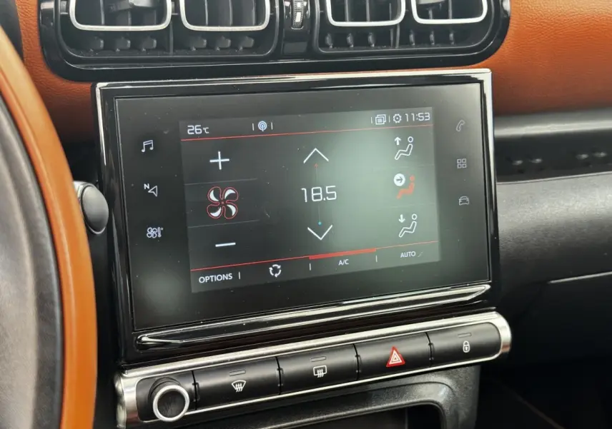 Écran tactile central affichant la climatisation à 18,5°C, entouré de garnitures noires et tableau de bord marron du Citroën C3 Aircross.