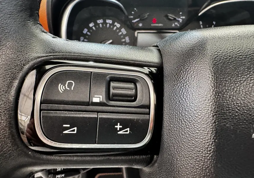 Gros plan sur les commandes vocales et volume du volant cuir noir de la Citroën C3 Aircross 2020.