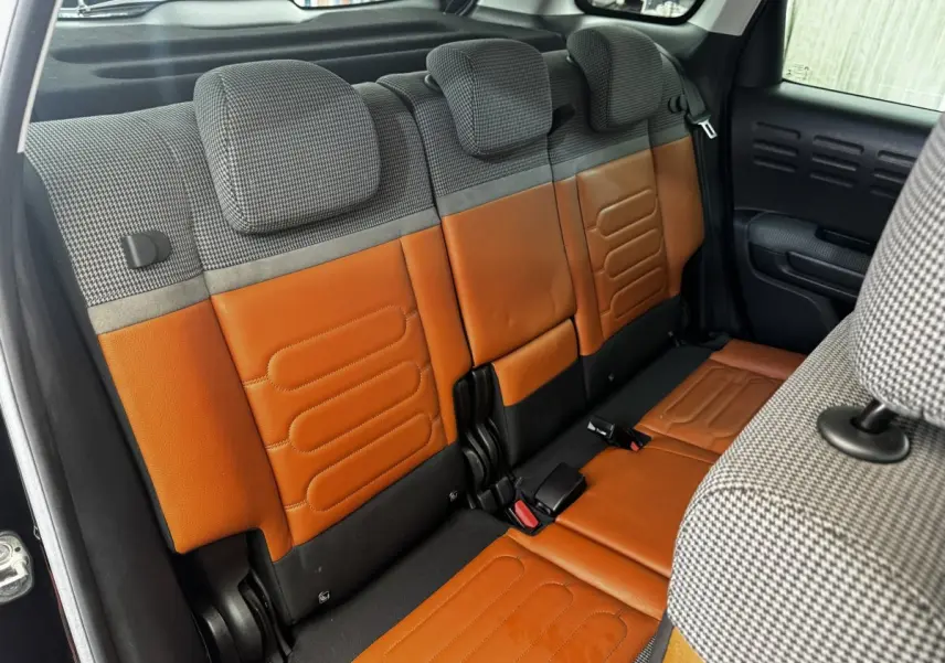 Vue intérieure sur la banquette arrière bicolore cuir marron et tissu gris à motifs du Citroën C3 Aircross 2020 noir.