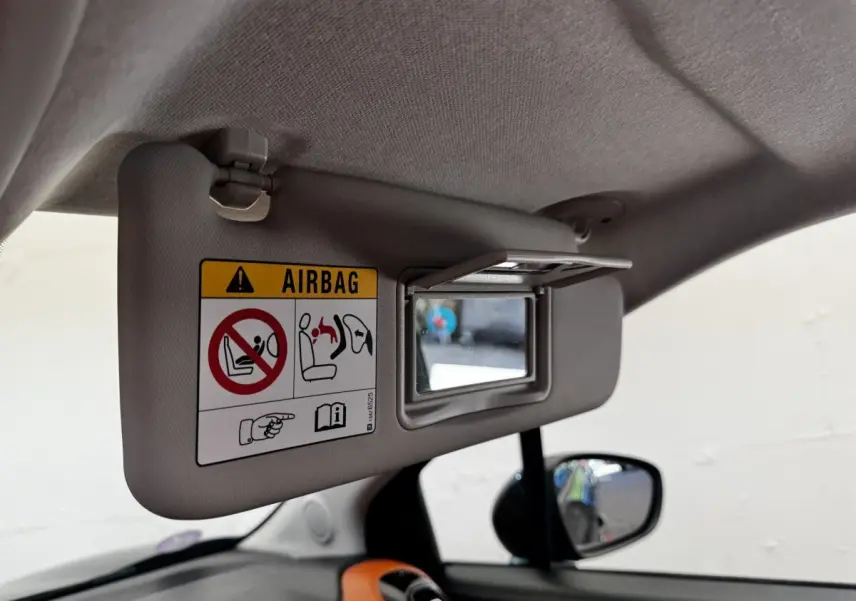 Vue intérieure du pare-soleil conducteur beige avec miroir et avertissement airbag dans une Citroën C3 Aircross noire.