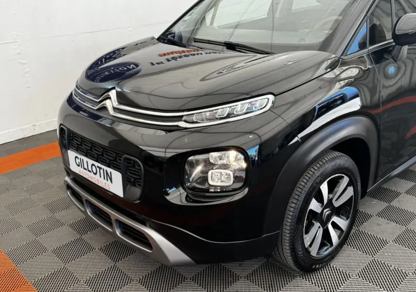 Vue 3/4 avant droit d'un Citroën C3 Aircross noir brillant avec feux LED et jantes alliage bicolores.