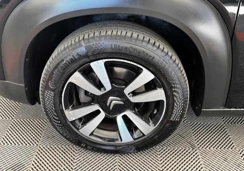Gros plan sur la roue avant droite noire d'une Citroën C3 Aircross 2020 avec jante alliage et logo Citroën central.
