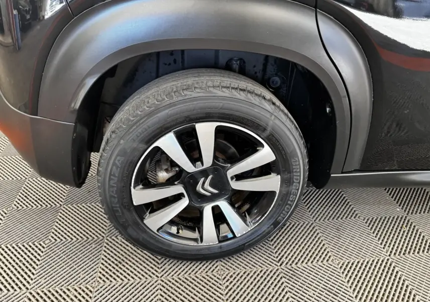 Gros plan sur la roue avant gauche noire avec jante alliage bicolore du Citroën C3 Aircross 2020.