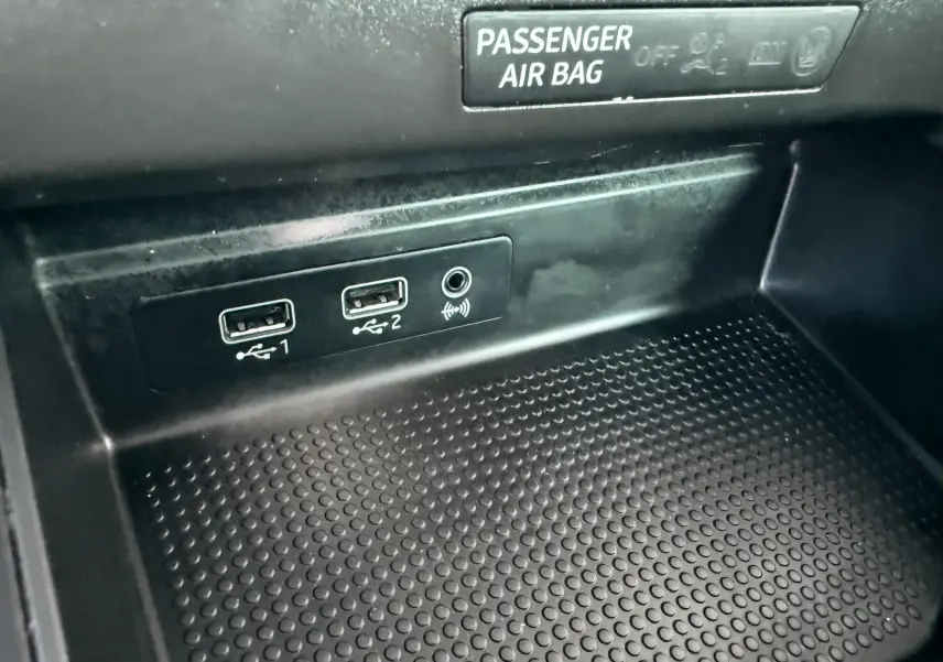 Gros plan sur la console centrale de la SEAT Ibiza rouge, montrant deux ports USB et une prise jack sous l'indicateur airbag passager.