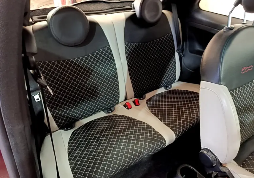 Vue intérieure sur la banquette arrière et siège avant de la FIAT 500 avec sellerie noire et beige à motifs losanges.