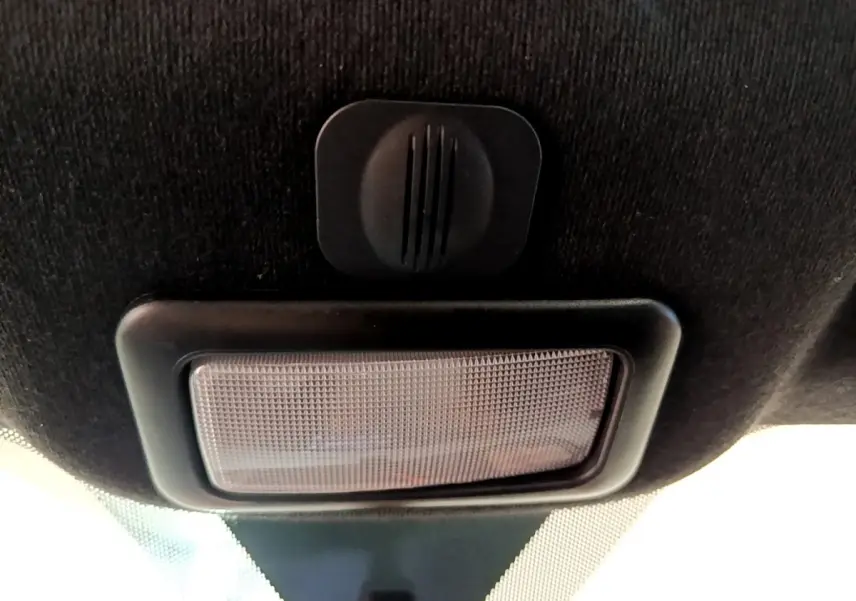 Plafonnier intérieur noir avec bouton de commande, vue en contre-plongée dans une Fiat 500 rouge 2021