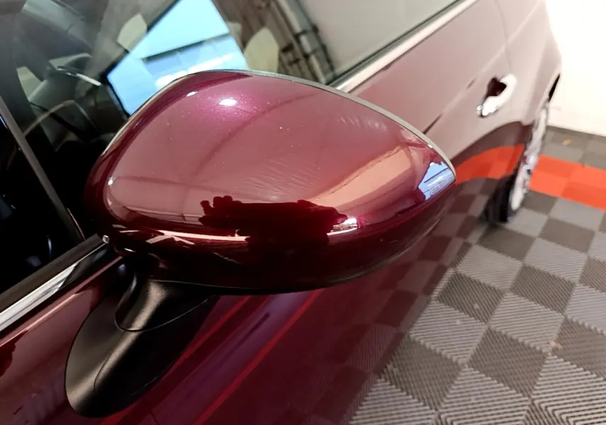 Gros plan sur le rétroviseur côté gauche rouge brillant de la FIAT 500 1.0 70ch BSG Star 2021, avec portière visible.