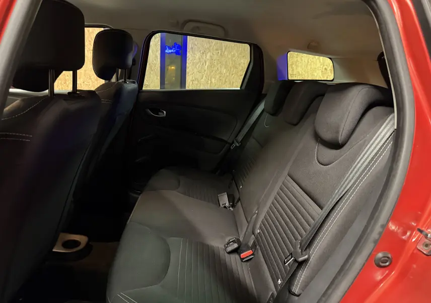 Vue intérieure arrière côté droit de la Renault Clio Estate IV rouge montrant les sièges arrière en tissu noir.