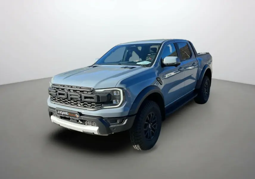 Ford Ranger Raptor gris commandeur vu en 3/4 avant droit avec calandre imposante et jantes noires.