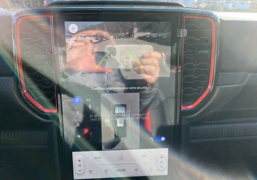 Écran central tactile du Ford Ranger Raptor 2025 avec caméra 360°, entouré de contours rouges sur tableau de bord noir.