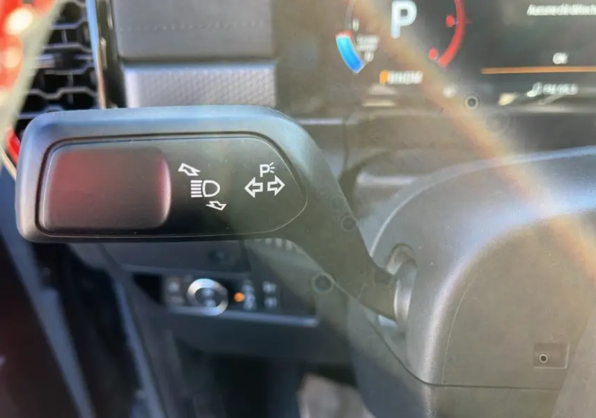 Gros plan sur la manette de clignotants et feux du Ford Ranger Raptor gris commandeur, intérieur côté gauche.