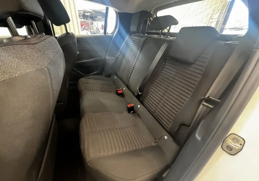 Vue intérieure côté droit sur la banquette arrière noire de la Peugeot 208 blanche, avec ceinture et appuie-têtes visibles.