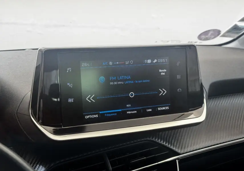Écran tactile central affichant la radio FM dans l'habitacle noir du Peugeot 208 PureTech 100 S&S Active Business.