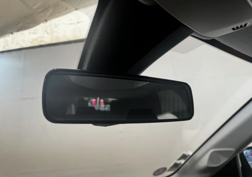 Rétroviseur intérieur de Peugeot 208 PureTech 100 blanc, vue rapprochée depuis l'habitacle côté conducteur.