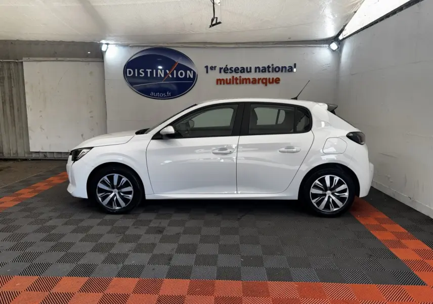 Profil côté gauche d'une Peugeot 208 blanche de 2020, avec jantes alliage et rétroviseurs noirs dans un showroom.
