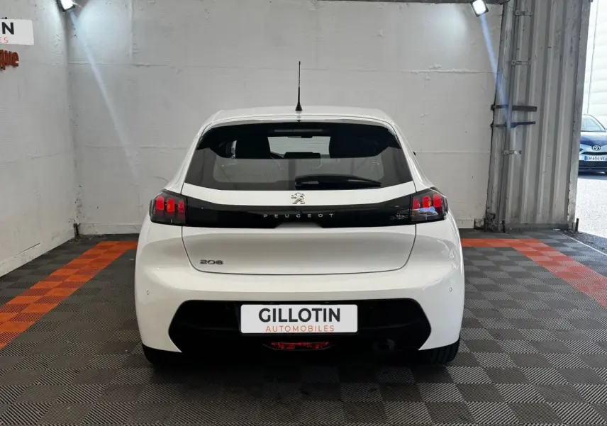 Vue arrière d'une Peugeot 208 blanche 2020 avec feux arrière noirs et logo Peugeot visible.
