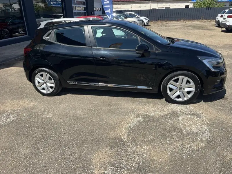 Profil côté gauche d'une Renault Clio 1.6 E-Tech 140ch Business 2020 en noir étoile avec jantes argentées et vitres teintées.