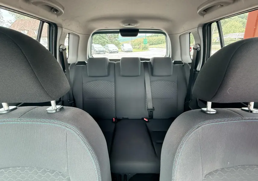 Vue intérieure arrière de la Mazda2 2004 montrant les sièges arrière et appuie-têtes en tissu noir.