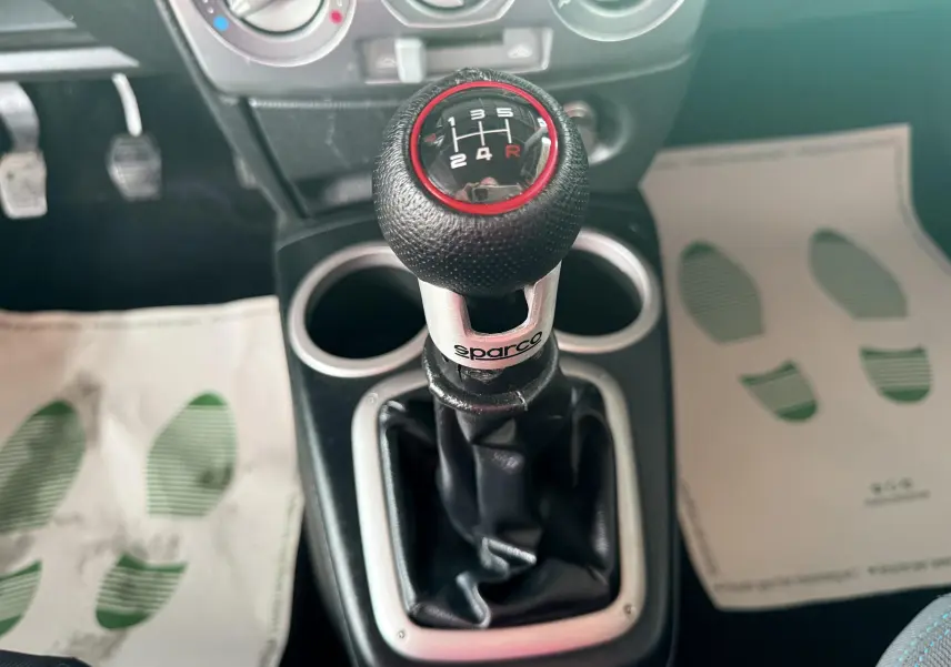 Le levier de vitesse manuel Sparco en gros plan dans l'habitacle d'une Mazda2 gris 2004.