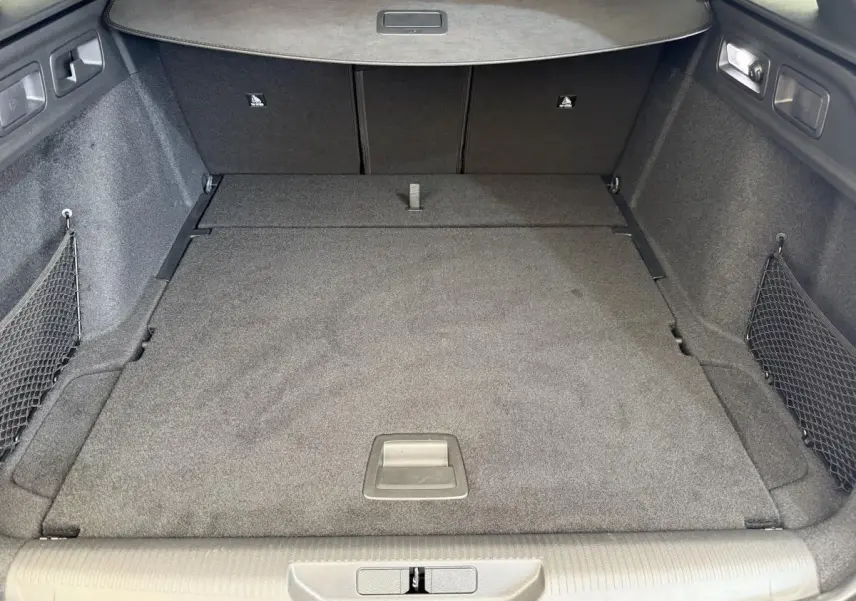 Vue intérieure du coffre spacieux et tapissé en gris foncé du Peugeot 308 Hybrid 136 e-DCS6 GT blanc 2024.