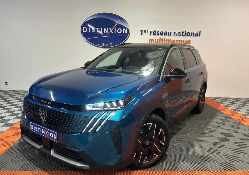 Peugeot 5008 III Hybrid 145 e-DSC6 GT bleu obsession en 3/4 avant droit avec calandre distinctive et jantes noires.