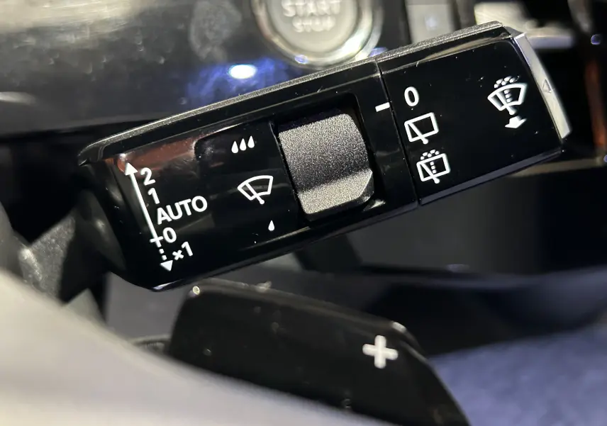 Gros plan sur la commande du lave-glace et essuie-glace du Peugeot 5008 III Hybrid 145 e-DSC6 GT, intérieur noir.