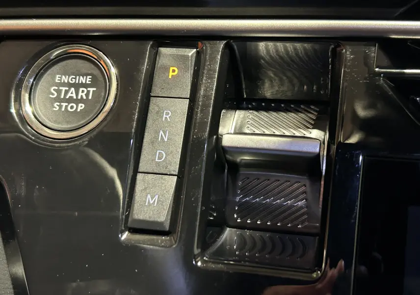 Gros plan sur la console centrale noire du Peugeot 5008 III HYBRID 145 e-DSC6 GT avec bouton start/stop et sélecteur de boîte auto.