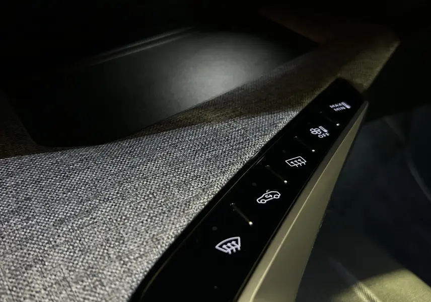 Gros plan sur les commandes tactiles de désembuage et ventilation sur la garniture grise intérieure du Peugeot 5008 Hybrid 2025.