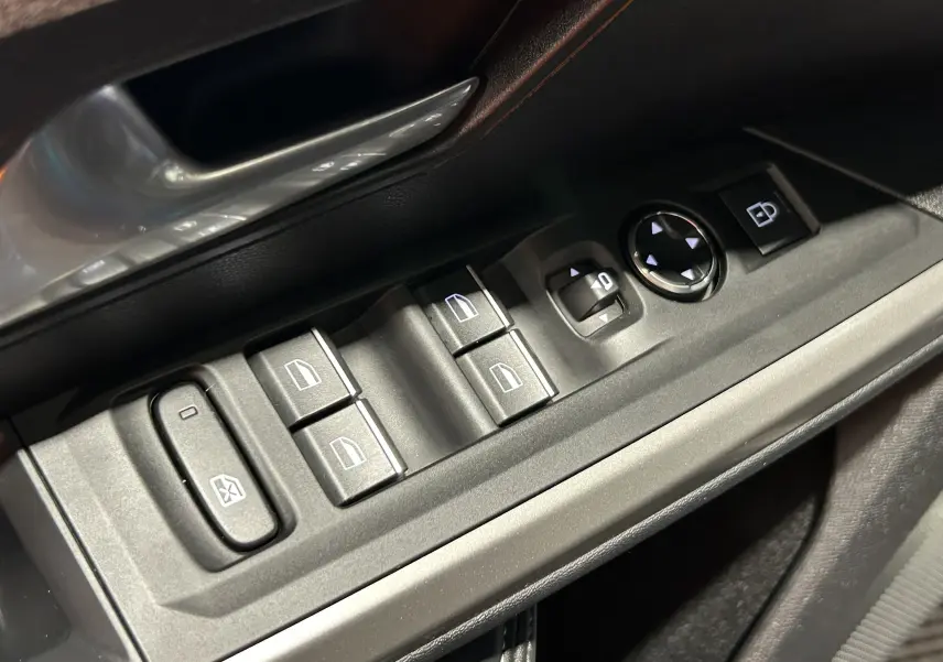 Gros plan sur les commandes électriques côté conducteur du PEUGEOT 5008 III HYBRID 145 e-DSC6 GT, finition noire.