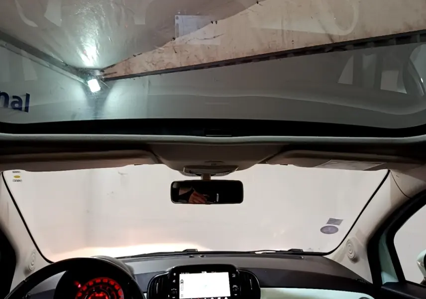 Vue intérieure avant du tableau de bord et volant cuir noir de la FIAT 500 Lounge 2019 avec toit panoramique.